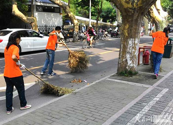 志願者幫助環衛工人清掃馬路。