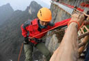 攀岩爱好者黄礼江身系安全绳,在悬崖峭壁上忙碌,一路捡拾游客遗弃山崖的杂物.［阅读］