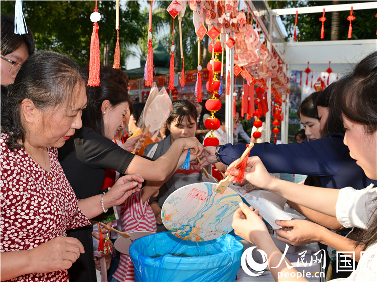观众在“欢乐春节嘉年华”活动现场体验漆扇制作。人民网记者 谢佳君摄 观众在“欢乐春节嘉年华”活动现场体验漆扇制作。人民网记者 谢佳君摄
