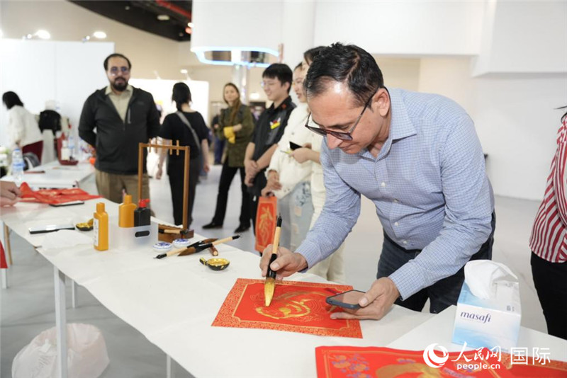 图为一位外国朋友学写书法,中东中心分社 塔里克·易卜拉欣摄 图为一位外国朋友学写书法,中东中心分社 塔里克·易卜拉欣摄