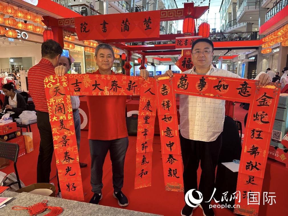 书法老师刘崇明与书法爱好者宋梦清展示各自书写的对联。人民网记者 简承渊摄 书法老师刘崇明与书法爱好者宋梦清展示各自书写的对联。人民网记者 简承渊摄