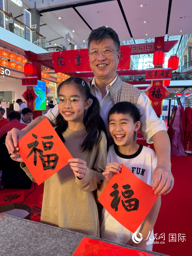 小朋友和凌平展示三人合作书写的“福”字。人民网记者 简承渊摄 小朋友和凌平展示三人合作书写的“福”字。人民网记者 简承渊摄