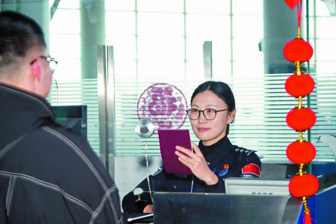 南通边检站执勤一队执勤一组组长贺乔波为旅客办理出境边检手续。本报记者王莉莉摄 南通边检站执勤一队执勤一组组长贺乔波为旅客办理出境边检手续。本报记者王莉莉摄
