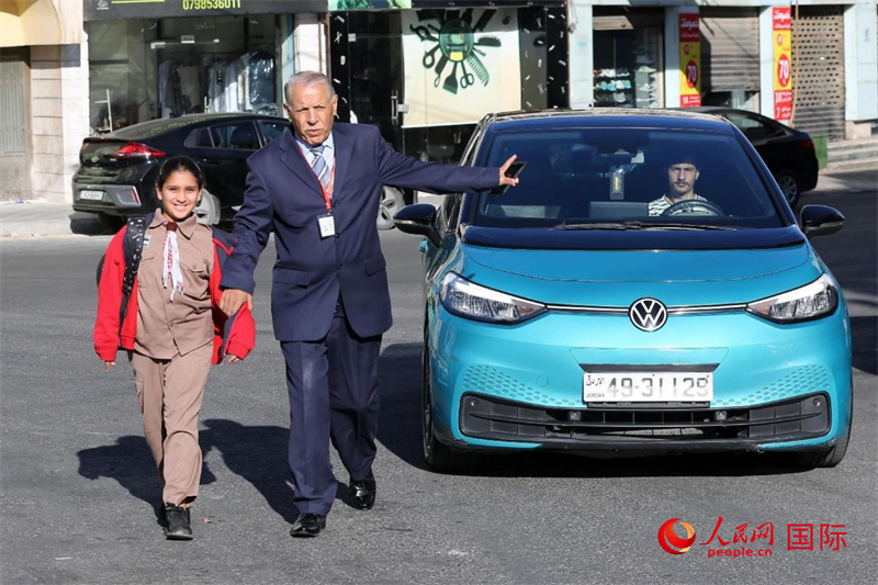 穆萨大叔带着孩子过马路。人民网 纳达尔·达乌德摄 穆萨大叔带着孩子过马路。人民网 纳达尔·达乌德摄