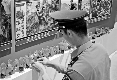 南部战区陆军某旅“英雄连”战士在荣誉室内摆放木棉花。 南部战区陆军某旅“英雄连”战士在荣誉室内摆放木棉花。