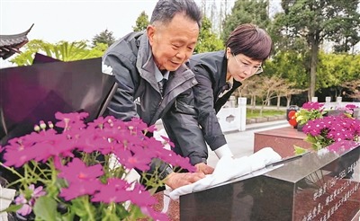 王太平父女擦拭杜治贤墓碑。顾建春摄 王太平父女擦拭杜治贤墓碑。顾建春摄