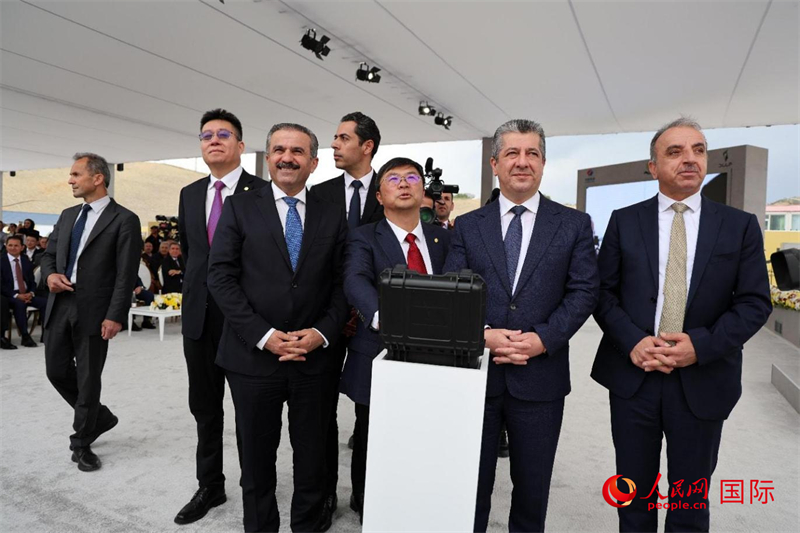 中伊嘉宾摁下按钮，共同启动水泥厂运行。人民网伊纳斯·易卜拉欣摄