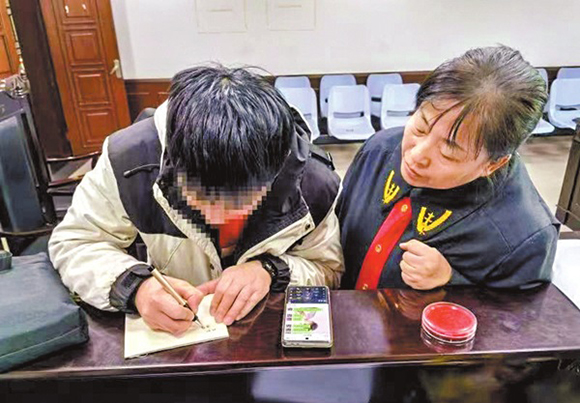 图为江苏省徐州市鼓楼区人民法院法官张向阳(右)用书写和微信打字的形式,与听障当事人”交流“案情。王蕴竹 摄 图为江苏省徐州市鼓楼区人民法院法官张向阳(右)用书写和微信打字的形式,与听障当事人”交流“案情。王蕴竹 摄