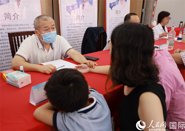 活动现场,成都中医药大学附属医院消化内科主任冯培民正在为当地侨胞把脉。人民网记者 宋亦然摄 活动现场,成都中医药大学附属医院消化内科主任冯培民正在为当地侨胞把脉。人民网记者 宋亦然摄