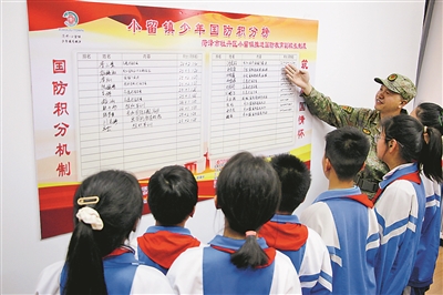 在小留镇党群服务中心,牡丹区人武部工作人员介绍“少年国防积分”榜上学生积分情况。刘继璐摄 在小留镇党群服务中心,牡丹区人武部工作人员介绍“少年国防积分”榜上学生积分情况。刘继璐摄