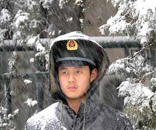 一名战士在大会堂外冒雪执勤。