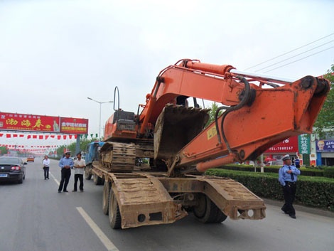 大型挖掘机爬上无牌半挂车