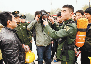 消防官兵向市民讲解消防空气呼吸器的使用方法