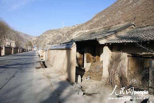 甘肃漳县殪虎桥乡东桥村,一间被墙所挡的民房(人民网记者 高翔 张鹏 隋欣 摄)