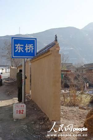 甘肃漳县殪虎桥乡东桥村里,修在212国道旁的“遮羞墙”(人民网记者 高翔 张鹏 隋欣 摄)