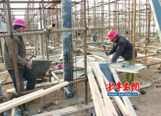 天气很冷，董女士和工友在安装钢筋。