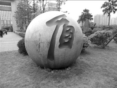 重庆市公安局门口的石球上,原局长王立军昔日题写的“盾”字如今已经消失。 