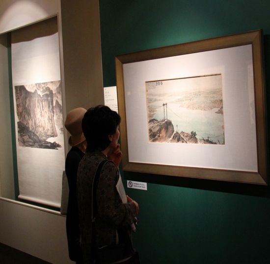 图1:日本观众欣赏展现中国大好山河和社会主义建设成果的《黄河清》(傅抱石、创作于1960年)。人民网记者刘军国摄