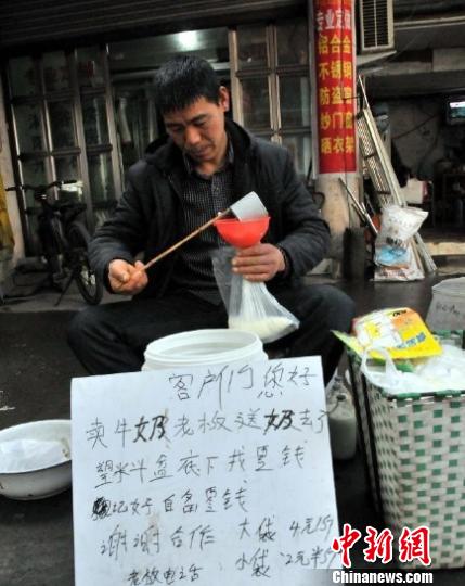 图为“牛奶叔”洪明更及他的“自助售奶“摊。