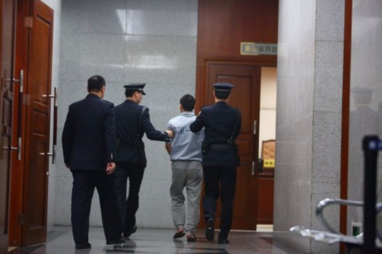 　3月25日，深圳，李才坤被押入法庭受审。
