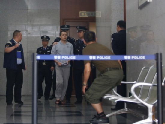 　3月25日，深圳，经过将近3个半小时的开庭审理后，李才坤被法警押出，带回看守所。
