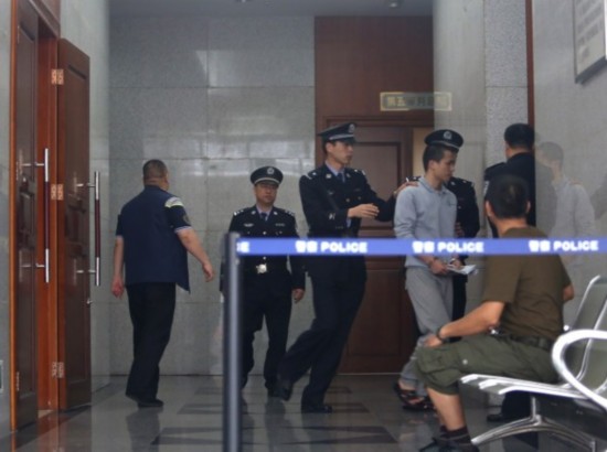 3月25日，深圳，经过将近3个半小时的开庭审理后，李才坤被法警押出，带回看守所。
