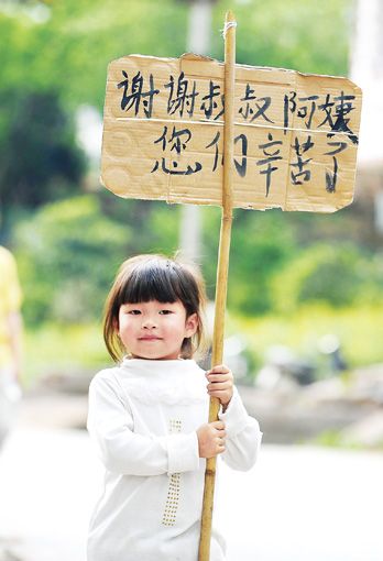 4月25日，雅安市天全縣老場鄉的公路邊，小朋友向救援人員致謝。 本報記者王建軍攝