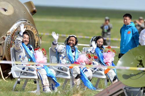 6月26日,这是圆满完成任务的三位航天员张晓光、聂海胜、王亚平(从左至右)自主出舱后向人们致意。新华社记者 任军川摄