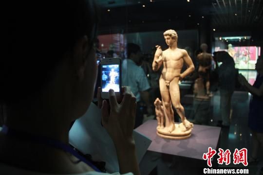 图为游客对雕像进行拍照 记者 张一辰 摄