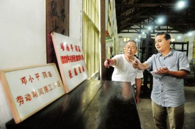 图为老工人陶端缙在现场向记者讲述当年小平劳动的情况。