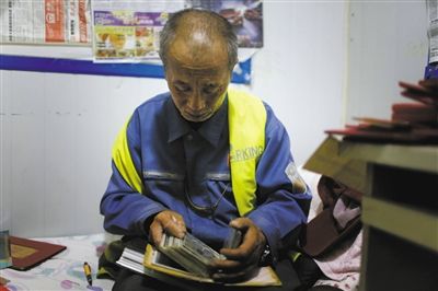 申凯的父亲看着儿子当兵时的照片，不禁流泪。