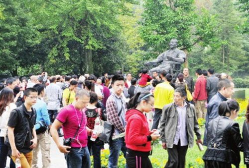 圖為游客瞻仰鄧小平銅像