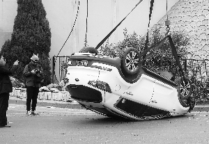 轿车拐弯玩漂移底朝天:砸断大树 撞破花坛