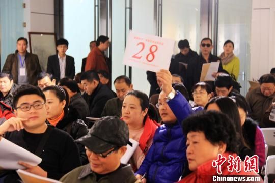 由山东省资源总公司主办的首届“慧眼识宝”书画拍卖会11月30日在济南阳光100文化艺术馆举行,图为竞拍者举牌叫价。 黄品璇 摄