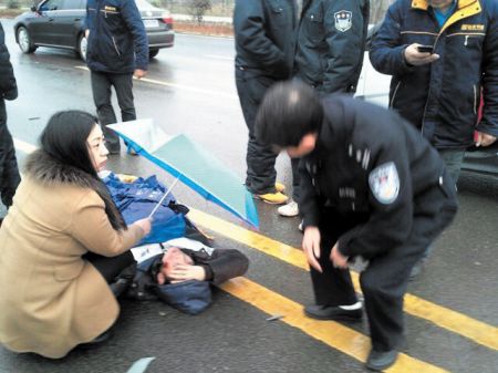 伤者长沙图片:车祸伤者倒地不起路人寒雨中为其撑伞半小时