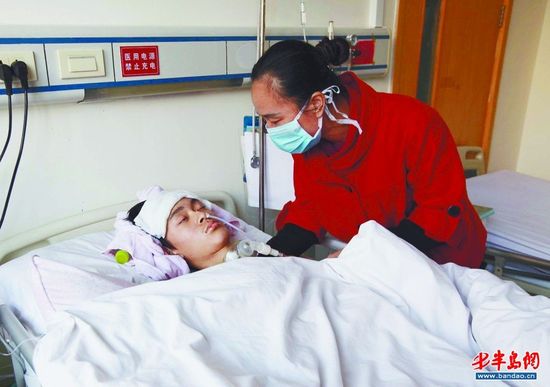 孩子的母亲黄女士照顾昏迷的小纪。