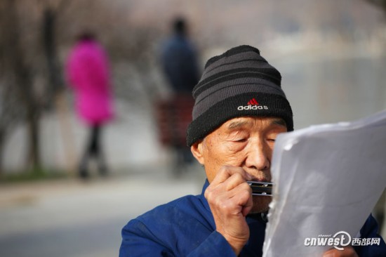 八旬大爷爱上吹口琴 每天背四五斤重歌谱享受