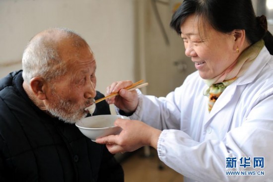 2月14日,敬老院工作人员喂老人吃元宵.