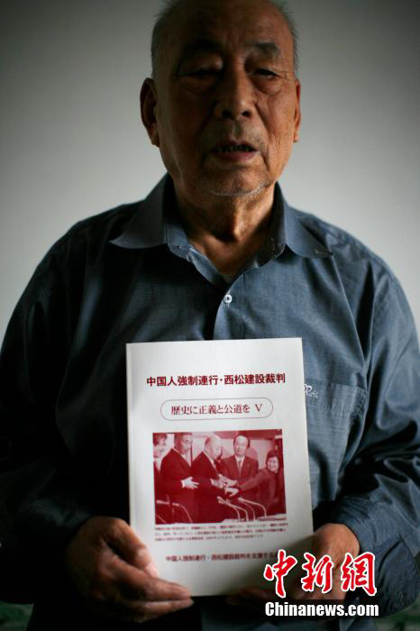 2月25日，89岁的天津籍赴日劳工幸存者邵义诚手拿介绍他参与“西松建设案”的书籍。中新社发 佟郁 摄