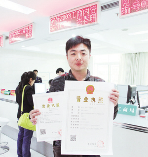 振鸿(漳州)建材有限公司负责人高兴地展示首张带二维码的新版营业执照