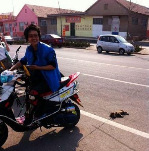 山东男子骑摩托车虐狗引围观 网友怒责其变态