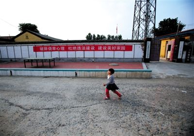 昨日，大兴榆垡镇崔指挥营村，村委会的外墙上挂有“杜绝违法建设”的标语。新京报记者 王叔坤 摄