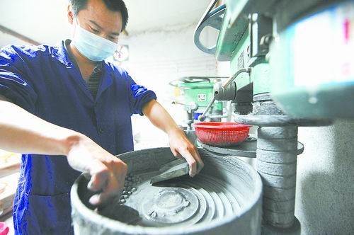 6月3日,工作人员在工作间用机器打磨金玉。