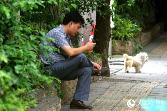 在考点外等待的家长独坐在花台边。（陈永斌摄）