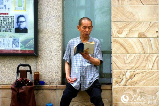 考生家长在考点外为考生诵读地藏经祈福。（陈永斌摄）