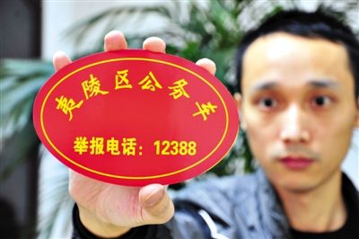 湖北省宜昌一位公车司机展示监督牌。公车私用等现象曾成为“潜规则”，在违反八项规定的案件中，公车违规高居榜首。资料图片