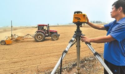 濮阳农民用激光平地机平整土地 可提高粮食产