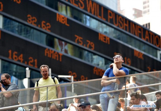 Tourists gather in front of the screens which shows the Dow Jones Industrial Index at the New York's Time Square in New York, the United States on July 3, 2014. U.S. stocks closed at record highs Thursday to end a holiday shortened week, with the Dow Jones Industrial Average settling above 17,000 points for the first time, boosted by stronger-than-expected U.S. nonfarm payroll report. 