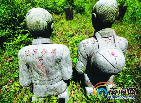 在文昌东阁镇金牛流坑村,日军军官下跪的雕像被放在遇害者墓碑前谢罪。陈元才摄