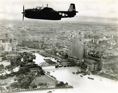 外白渡桥和苏州河 拍摄时间:1945年9月8日 黄浦江上空,照片自东向西拍摄。苏州河口的建筑清晰可见,外白渡桥北侧的百老汇大厦上还看得到“兴亚”的字样,这是上海沦陷后日军强行更改的名字。乍浦路桥和外白渡桥间的码头上停着很多中式帆船;照片左侧可见外滩公园、新天安堂、邮政总局和新亚大酒店的尖塔;远处的虹口区还没有太多高楼,如今则大不一样了。
